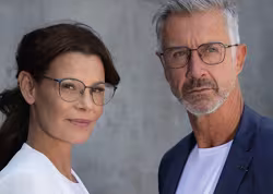 Ein Mann und eine Frau tragen jeweils eine Brille der Marke Ruud Van Dyke.