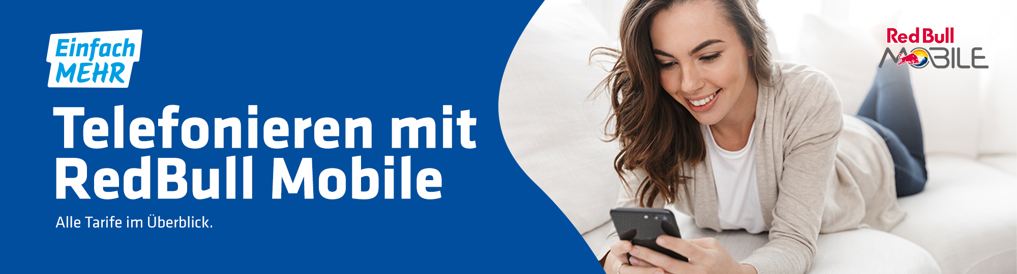 junge Frau liegt auf Sofa und schaut lächelnd in ihr Smartphone mit Logo von Red Bull Mobile
