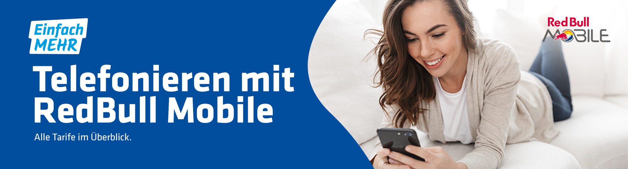 junge Frau liegt auf Sofa und schaut lächelnd in ihr Smartphone mit Logo von Red Bull Mobile
