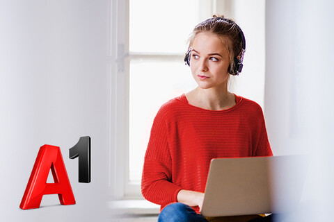  junge Frau mit Laptop und Kopfhörern vor Fenster neben A1 Logo
