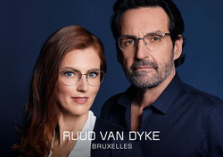 Reifes elegantes Paar mit Ruud van Dyke Gleitsichtbrillen vor blauem Hintergrund.