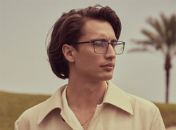 junger Mann trägt Baldessarini Brille und Palmen im Hintergrund