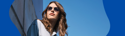 "junge Frau mit stylischer Sonnenbrille vor Betonwand"