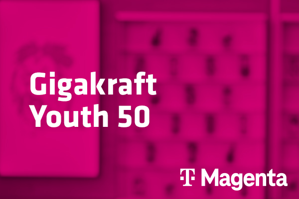  Tarif Gigakraft Youth 50 und Magenta-Logo vor unscharfem magentafarbenem Hintergrund mit Handyabteilung in Hartlauer Geschäft
