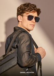 Sportlicher junger Mann mit Tasche und Daniel Hechter Sonnenbrille.