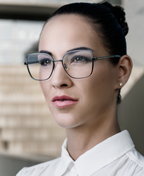 Eine Frau mit zurückgebundenen dunklen Haaren trägt eine Brille der Marke Robert Rüdger.