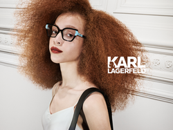 Junge hellhäutige Frau mit auffälligen roten Haaren trägt Karl Lagerfeld Kuknststoffbrille.