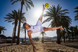 Aufnahme eines Footvolley-Spielers, wie er in springender Position versucht den Ball zu berühren.