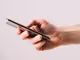 ein Smartphone mit Displayschutz in einer Hand 