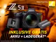 Nikon Z52 Kamera mit Akku und Ladegerät auf orangem Hintergrund mit folgendem Text: "Z52 inklusive gratis Akku und Ladegerät."