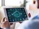 ein Mann hält ein Tablet zum Steuern des Smart Home in den Händen
