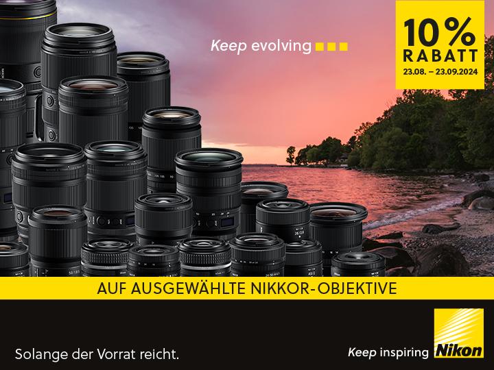 Grafik zur Bewerbung der Nikon -10% Objektivwochen. Auf der Grafik sind viele nebeneinander gereihte Objektive zu sehen. Der Hintergrund zeigt einen Kieselstrand bei Sonnenuntergang mit einigen Bäumen. Auf der Grafik steht folgender Text: "Keep evolving. 10% Rabatt 23.08. bis 23.09.2024. Auf ausgewählte Nikkor-Objektive. Solange der Vorrat reicht. Keep inspiring. Nikon."