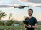 Mann steuert eine Drohne, die direkt vor ihm schwebt
