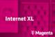 Tarif Internet XL und Magenta-Logo vor unscharfem magentafarbenem Hintergrund mit Handyabteilung in Hartlauer Geschäft
