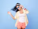 tanzende Frau mit blauer Sonnenbrille und weißen Over-Ear Kopfhörern