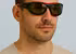 Ein Mann trägt eine schwarz-rote Sportbrille.