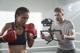 ein Kameramann hält eine DJI Gimbal in der Hand und filmt eine Boxerin
