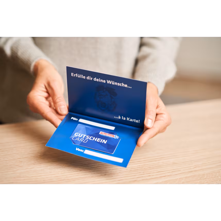 Hartlauer Gutscheincard im passenden Umschlag wird von zwei Händen gehalten