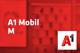 A1 Mobil M  Tarif und A1-Logo vor unscharfem roten Hintergrund mit Handyabteilung in Hartlauer Geschäft