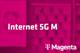 Tarif Internet 5G M und Magenta-Logo vor unscharfem magentafarbenem Hintergrund mit Handyabteilung in Hartlauer Geschäft