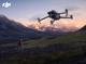 Mann steuert DJI Drohne in einer Berglandschaft