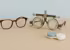 Eine Brille, eine Messbrille und ein Kontaktlinsenbehälter liegen nebeneinander.