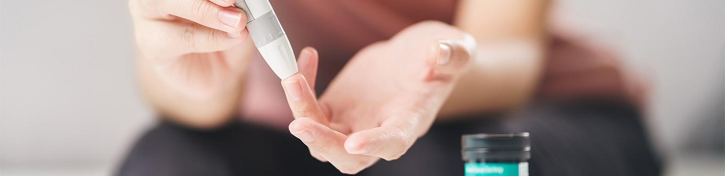 Nahaufnahme von Frauenhänden, die einen Insulinpen benutzen

