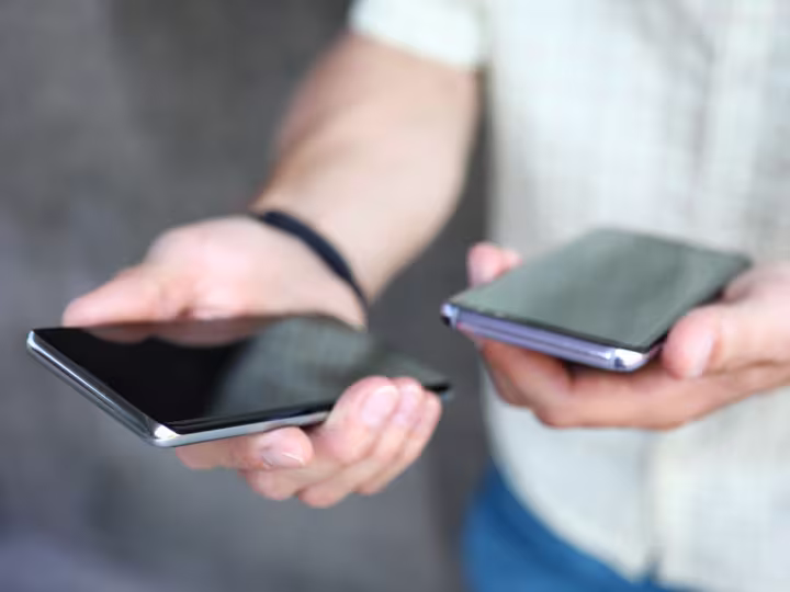 Eine Person hält zwei Smartphones in ihren Händen.