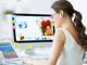 Frau gestaltet ein CEWE FOTOBUCH auf einem Mac, auf dem Kinderfotos zu sehen sind, daneben ein Tablet 
