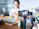 Smartphone mit Gimbal und viele schwebende Emojis vor verschwommenen Hintergrund