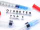 Buchstabenwürfel formen den Begriff Diabetes Typ 1 neben Spritzen