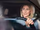 lächelnde Frau mit Brille im Auto