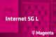 Tarif Internet 5G L und Magenta-Logo vor unscharfem magentafarbenem Hintergrund mit Handyabteilung in Hartlauer Geschäft