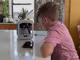 Ein Junge sitzt vor einem 3D-Drucker.