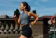 Eine junge Frau joggt in einer Stadt und trägt eine Smartwatch von Garmin.