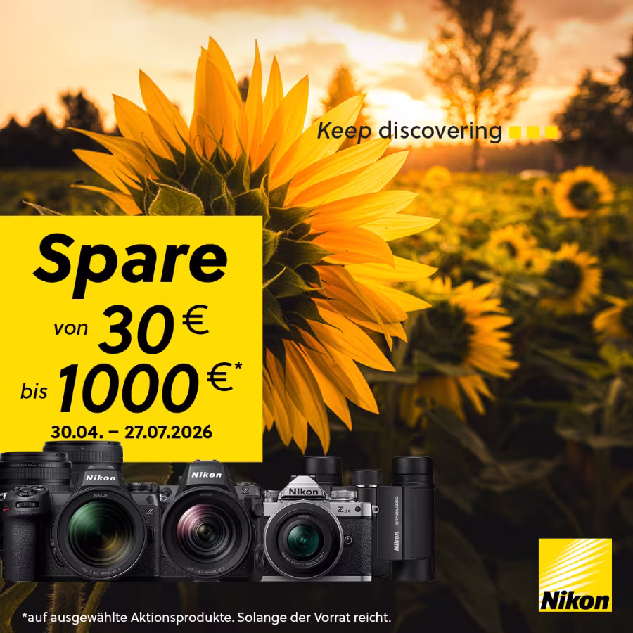 Nahaufnahme einer Sonnenblume im warmen Abendlicht als Hintergrund f&uuml;r eine Nikon-Aktion. Gelbes Textfeld mit &bdquo;Spare von 30 &euro; bis 1000 &euro; (30.04.&ndash;27.07.2026)&ldquo;. Unten Nikon-Kameras und Zubeh&ouml;r, rechts unten das Nikon-Logo und oben der Slogan &bdquo;Keep discovering&ldquo;.
