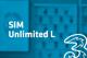 Tarif Drei SIM Unlimited L und Drei-Logo vor unscharfem türkisem Hintergrund mit Handyabteilung in Hartlauer Geschäft
