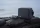 Eine DJI Avata 2 und die zugehörige Umhängetasche befinden sich auf einem Felsen.