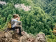 jungerer Wanderer in den Bergen schaut durch Fernglas